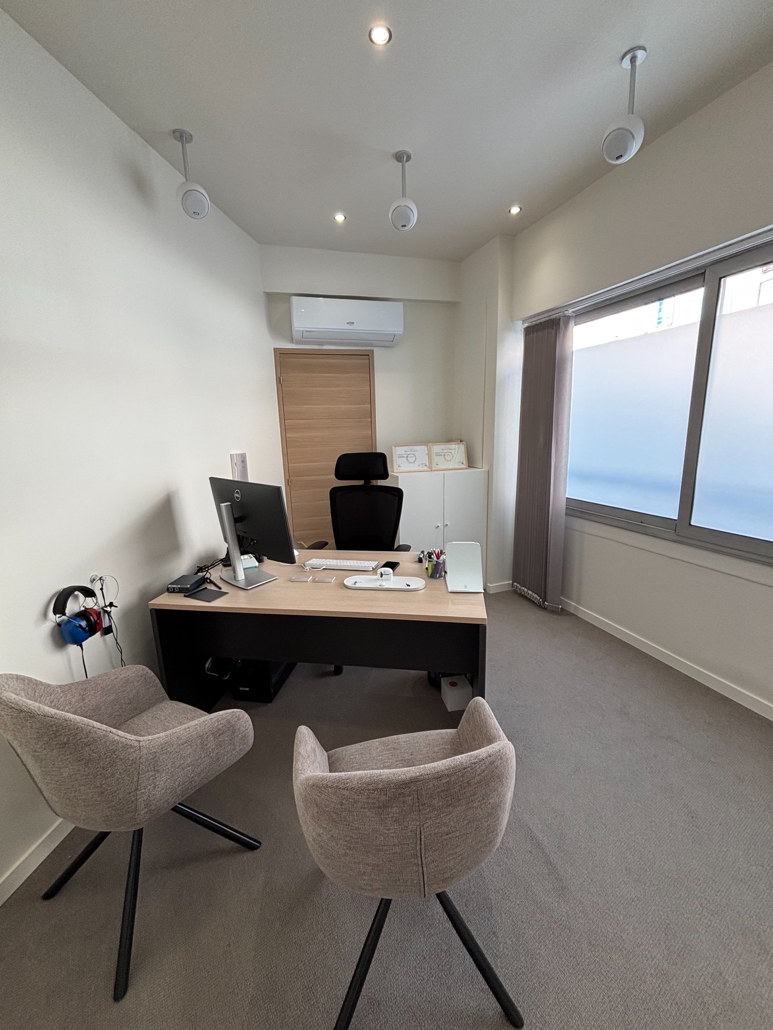 Cabine du centre de Grigny avec bureau, fauteuils et équipement de bilan auditif